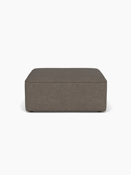 Front view of the Eave Modular Sofa Pouf 96. The square pouf is upholstered in dark, textured bouclé fabric.