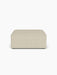 A front-on view of the Eave Modular Sofa, 96, Pouf, a rectangular pouf upholstered in a light beige textured fabric.