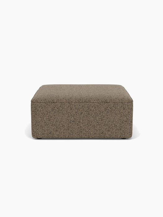 Front view of the Eave Modular Sofa Pouf, 96, upholstered in a textured brown Safire 001 fabric, on a white background.