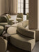 A lounge setting with a curved, beige Eave Seamline Modular Sofa, Tearoom Side Chairs and Androgyne Side Tables.