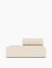 A front-on view of the Eave Seamline Modular Sofa's open-end module, upholstered in a light-coloured textured fabric.