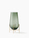 The small Echasse Vase, a smokey green glass vessel held in a slender, four-legged brass stand on a white background.