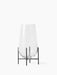 The small Echasse Vase in clear glass shown from the front. The teardrop-shaped vase sits in a minimal black metal stand.