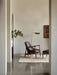A living room featuring the brown leather Elizabeth Lounge Chair, matching Ottoman, and a Wing Floor Lamp on a striped rug.