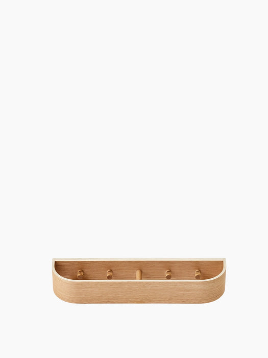 Front view of the Epoch Rack 50 in natural oak. The wall shelf has a minimalist, curved design with five internal pegs.