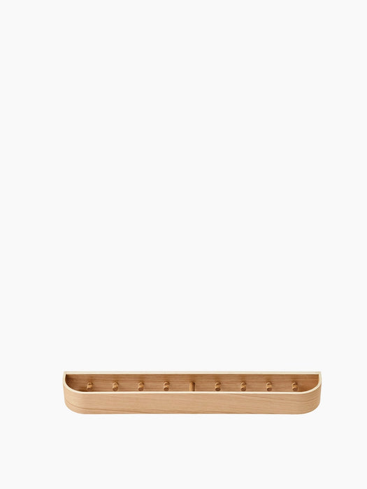 Front view of the Epoch Rack 79 in natural oak, a long wall-mounted wooden shelf with several pegs inside a curved frame.
