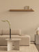 A minimalist living room with an Eave Modular Sofa, Androgyne Side Table, Stance Vase, Volume Side Table, and Epoch Shelf.