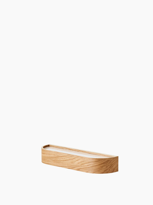 A low-angle shot of the Audo Epoch Shelf 50. The minimalist wall shelf is made from natural oak with a soft, curved design.