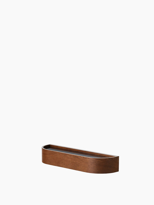 A low-angle view of the Epoch Shelf 50. The minimalist, curved wall shelf has a dark stained wood finish.