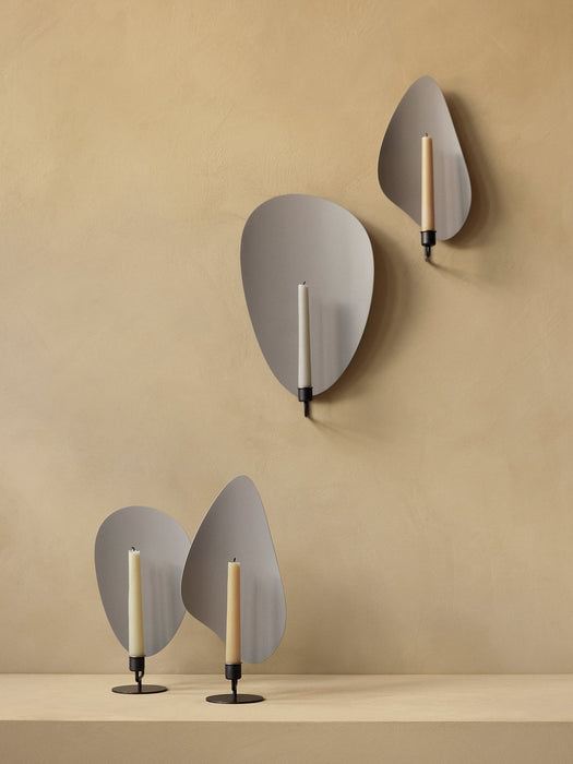 A group of four Flambeau Candle Holders, two mounted on a beige wall and two standing on a table against the same wall.