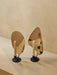 A pair of Flambeau Candle Holders with black bases and polished brass reflectors. One holds a pink candle, the other white.