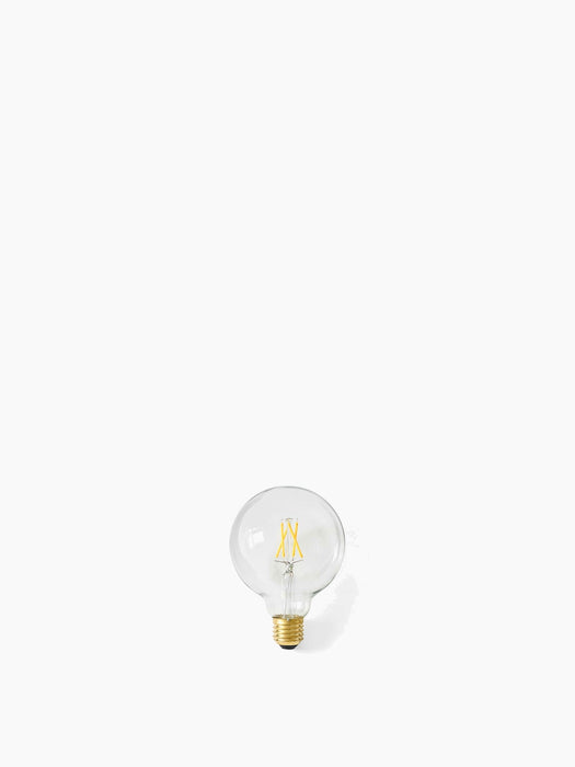A clear, spherical Globe LED Bulb with a visible yellow filament and a brass-colored screw base on a white background.