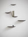 A group of five dark oak Gridy Fungi Shelves mounted on a white wall, styled with a book and a small ceramic cup.