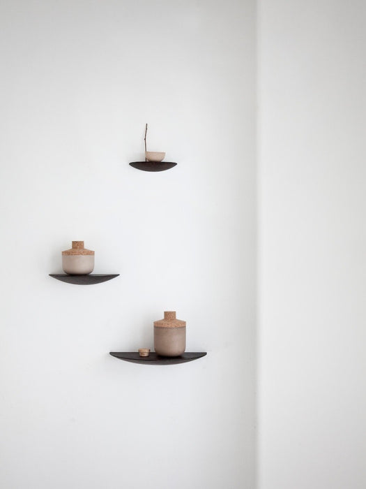 Three dark Gridy Fungi Shelves mounted on a white wall, styled with small ceramic vessels with cork stoppers and a twig.