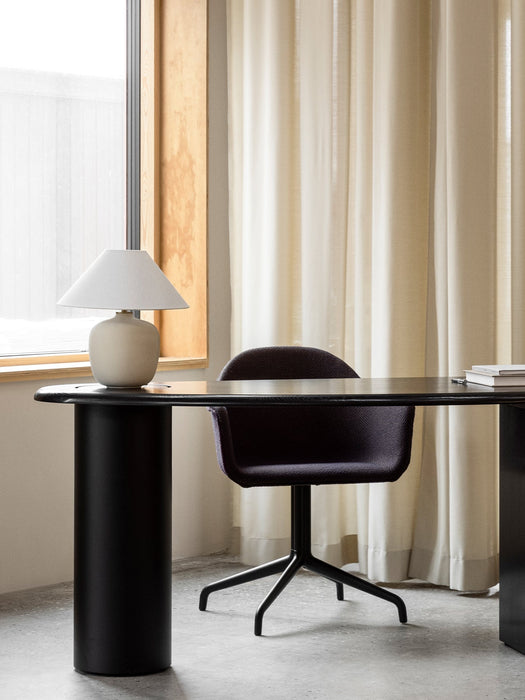 A purple Harbour Dining Chair at a black Eclipse Desk. A Torso Table Lamp sits on the desk by a window with sheer curtains.