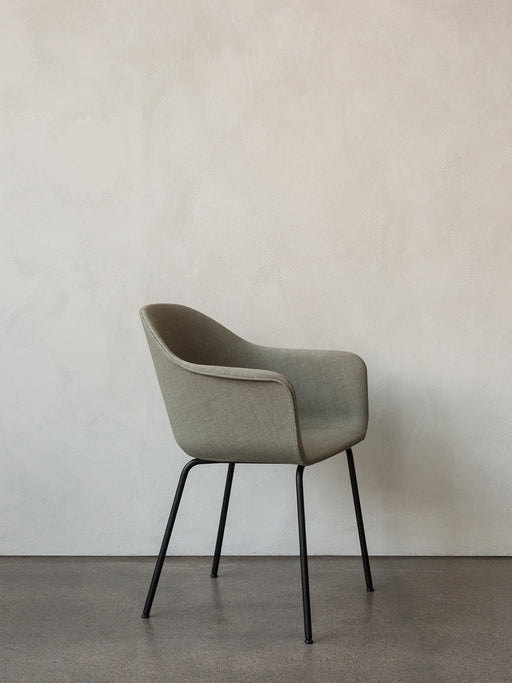 A Harbour Dining Chair with a curved, sage green upholstered seat and slim black steel legs, shown against a white wall.