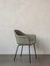 A Harbour Dining Chair with a curved, sage green upholstered seat and slim black steel legs, shown against a white wall.
