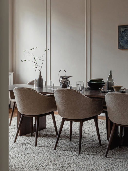 Harbour Dining Chairs surround a table with a Triptych Bowl, Etruscan Pitcher, and Stem Vase, set on a Gravel Rug.