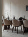 Harbour Dining Chairs surround a table with a Triptych Bowl, Etruscan Pitcher, and Stem Vase, set on a Gravel Rug.