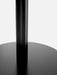 A close-up shot of the base of the black Harbour Column Table, highlighting the fluted column and the flat, circular base.