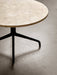 A close-up of the Harbour Column Lounge Table with a round Kunis Breccia stone top and a black star-shaped metal base.