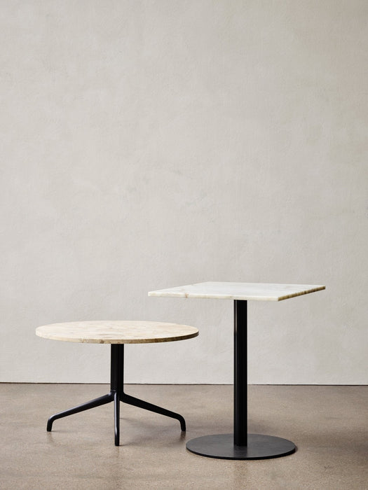 A Harbour Column Lounge Table with a round stone top and star base, next to a taller, square Harbour Column Dining Table.