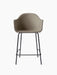 Front view of the Harbour Counter Chair, Upholstered. Features a light brown fabric shell on a slender, black metal frame.