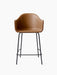 A Harbour Counter Chair seen from the front, with a tan leather upholstered shell, armrests, and a tall black steel base.