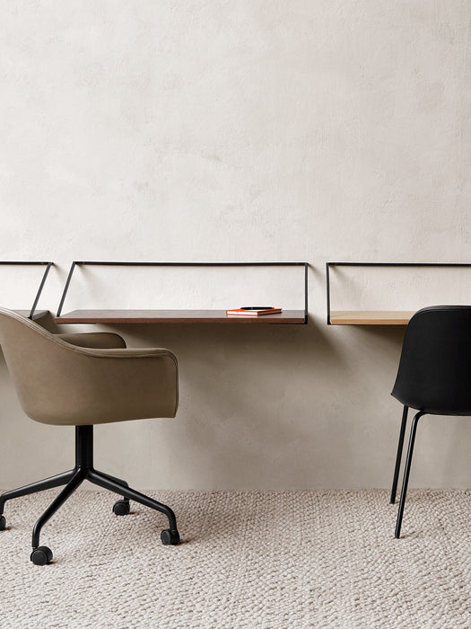 A brown Harbour Dining Chair and a black Side Chair at two wall-mounted Rail Desks, placed on a light-coloured Gravel Rug.