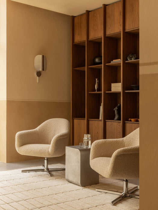 Two beige Harbour Lounge Chairs on a Tile Rug, styled with a Volume Side Table, Wing Wall Lamp, and a wooden bookshelf.