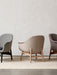 Three Harbour Lounge Chairs with different upholsteries and wood frames are lined up against a plain wall on a textured rug.