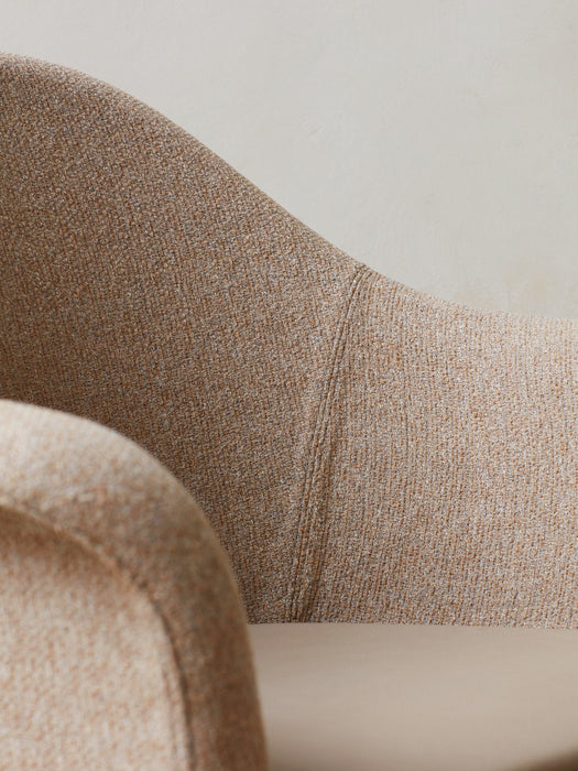 A close-up of the Harbour Lounge Chair, showing its textured beige and brown woven upholstery and curved backrest.