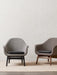 Two Harbour Lounge Chairs on a woven rug. One is grey with a black frame, the other is brown with a natural wood frame.