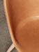 Close-up of the Harbour Side Dining Chair's tan leather seat, highlighting its fine stitching and light oak leg.