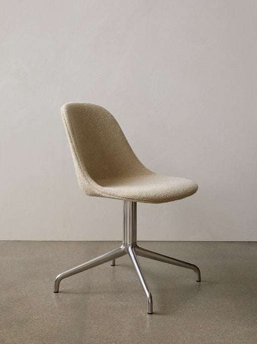 Angled view of the Harbour Side Dining Chair with light, textured upholstery and a polished aluminium star base.