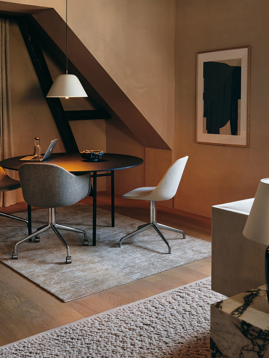 Two Harbour Side Dining Chairs with Polished Aluminium Star Bases at a round black table in an earth-toned dining space.