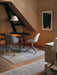 Two Harbour Side Dining Chairs with Polished Aluminium Star Bases at a round black table in an earth-toned dining space.