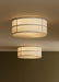 Two lit Hashira Ceiling Lamps with raw linen shades and dark steel frames flush-mounted on a cream ceiling above a dark wall
