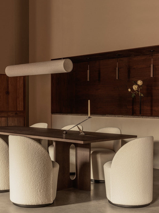 A minimalist dining room with the Hashira Linear Pendant Lamp over an Androgyne Dining Table and white Tearoom Side Chairs.