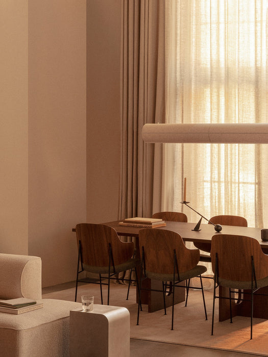 Hashira Linear Pendant over an Androgyne Dining Table and Penguin Chairs, with an Eave Modular Sofa in a softly lit room.