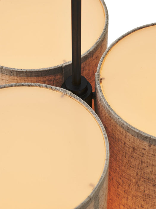 Close-up top view of the Hashira Pendant Lamp, Cluster, showing three illuminated cylindrical lampshades in raw linen.