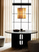 The Hashira Pendant Cluster lamp illuminates an Androgyne Dining Table with Cairn Poufs in a softly lit dining room.