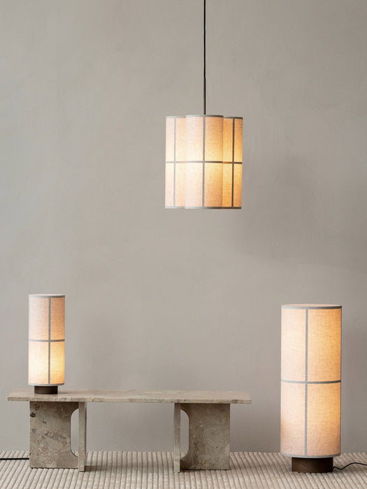 A Hashira Pendant Lamp Cluster, Floor Lamp and Table Lamp illuminate a minimalist room with a stone Androgyne Lounge Table.
