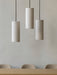 Three Hashira Pendant Lamps hang in a row above the Androgyne Dining Table & Harbour Side Dining Chairs in a minimal setting.