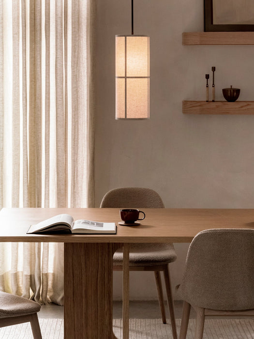 A Hashira Pendant Lamp illuminates an Androgyne Dining Table, Harbour Chairs, and Epoch Shelf in a warm, neutral dining room.