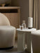 The Hashira Table Lamp, Portable on a marble side table, styled next to a Tearoom Side Chair in a soft, neutral-toned room.