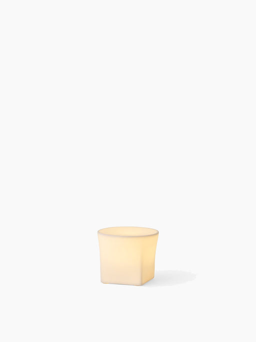 The small, square-shaped Ignus Flameless Candle (H8) made of bone china, glowing with a warm light on a white background.