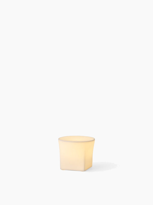 Ignus Flameless Candle, H8 size, a short, sculptural bone china candle, glowing with warm light against a white background.