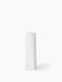 A tall, sculptural Ignus Flameless Candle in matte white bone china. It has a square base and tapers to a round top.