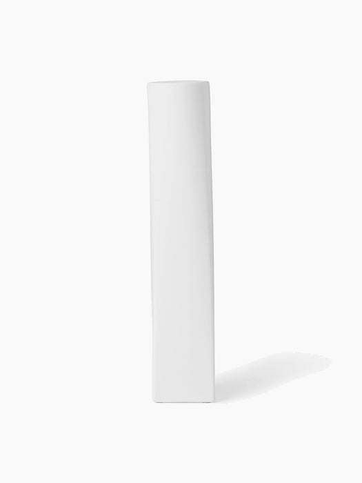A front view of the tall, sculptural Ignus Flameless Candle. It is made of matte white bone china on a white background.